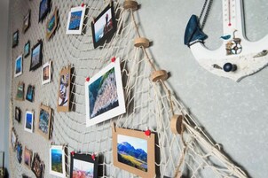 Una pared con una estructura similar a una red que sostiene varias fotografías.