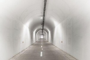 Un túnel largo y recto con una escalera que lleva al techo.
