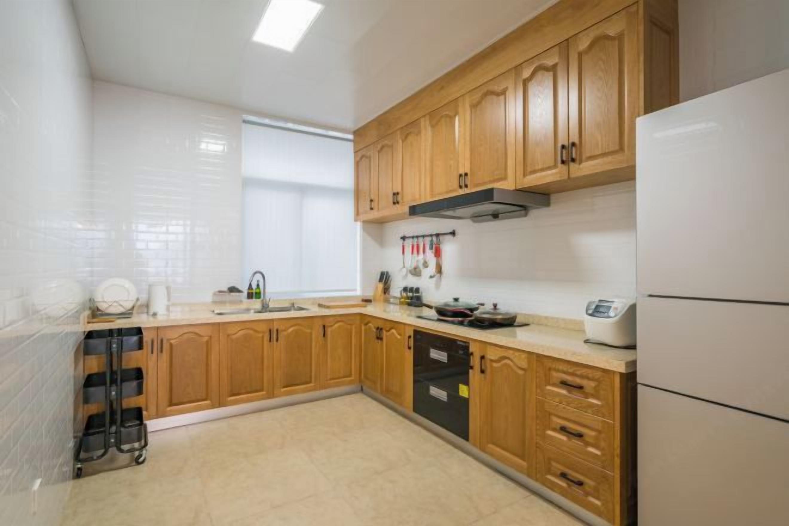 A kitchen with wooden cabinets, a dishwasher, and a refrigerator.