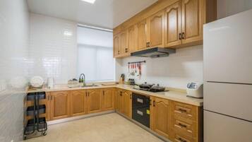 A kitchen with wooden cabinets, a dishwasher, and a refrigerator.