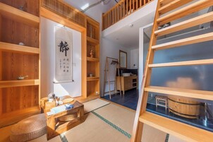 Una habitación japonesa tradicional con suelo de tatami, estanterías de madera y una mesa baja de madera.