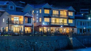A waterfront hotel with multiple floors, balconies, and a restaurant area. - Shatang Jingwan Inn (Xiangshan)