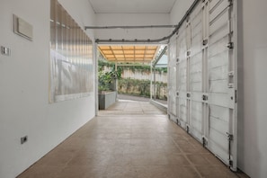A corridor with a tiled floor leading to a garage door.
