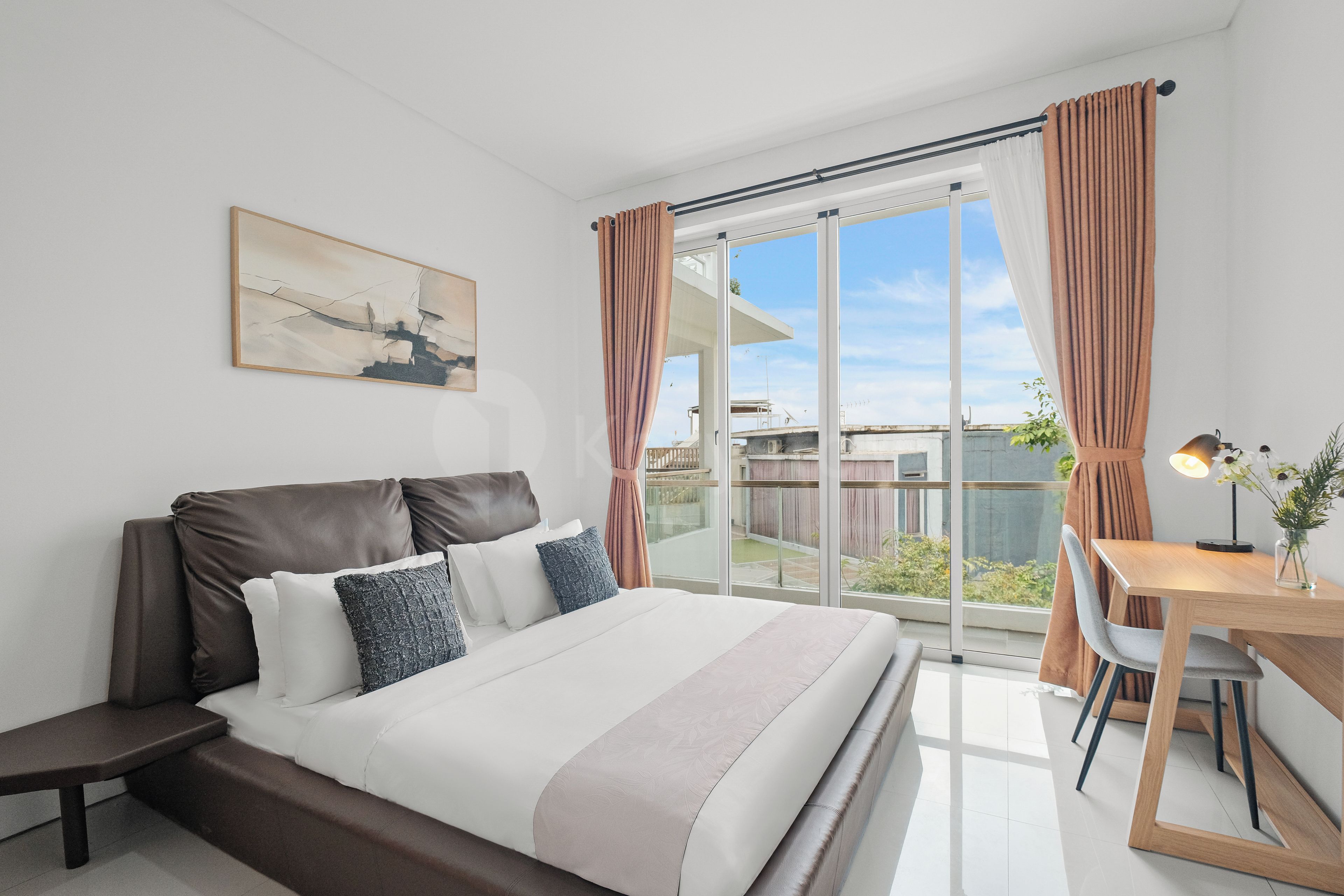 Une chambre moderne avec un grand lit, un bureau et une vue sur l’extérieur.