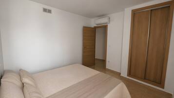 Ein Schlafzimmer mit einem Bett, einem Kleiderschrank und einer Klimaanlage.