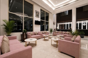 A spacious lobby with large windows, plush seating, and a modern design. - The Platinum Grand Mamta (Srinagar)