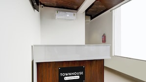 A reception desk with a sign that reads 'TOWNHOUSE Company-Serviced.' - Super Townhouse Badangpet Crossway (Hyderabad)