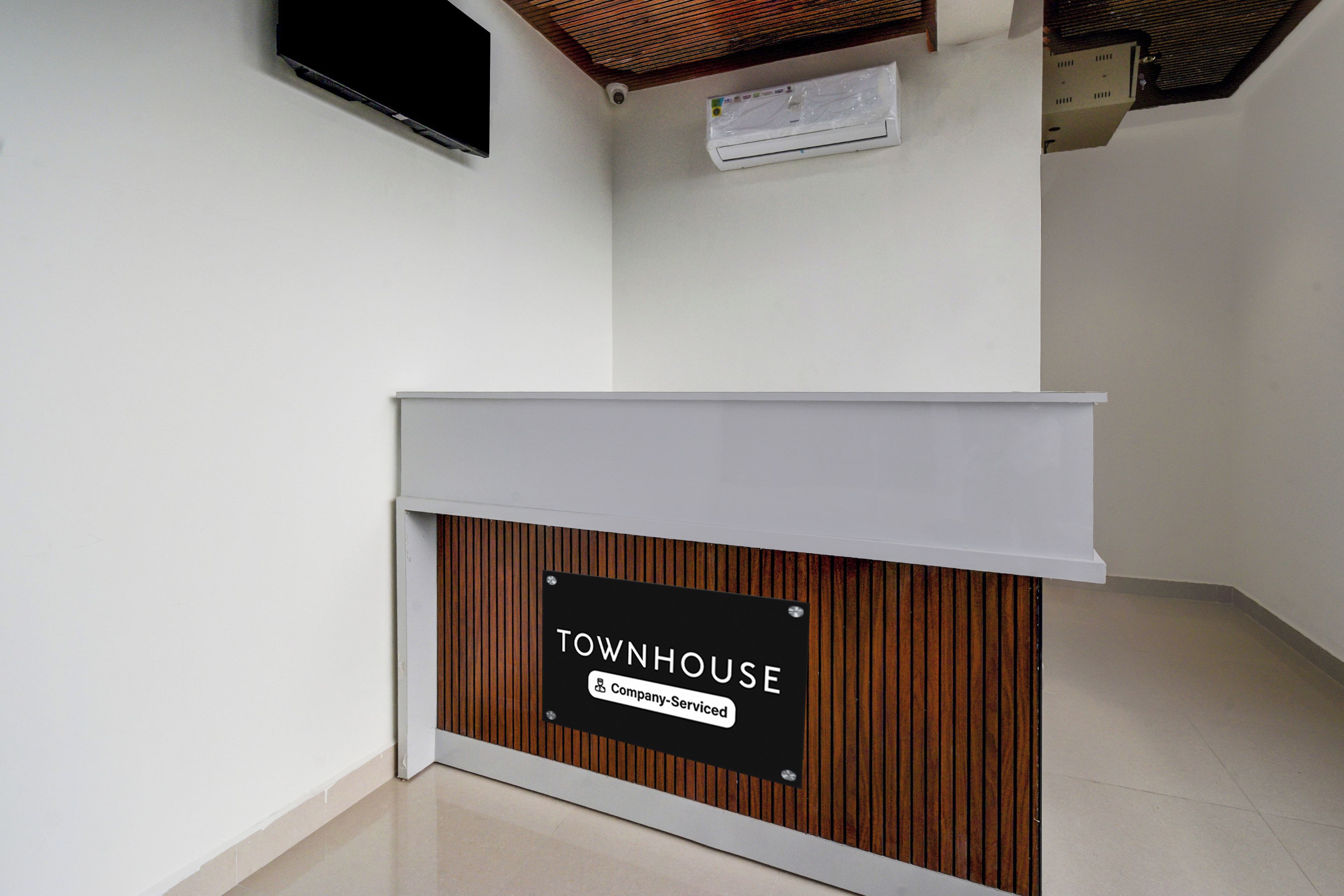 A reception desk with a sign that reads 'TOWNHOUSE Company-serviced.'