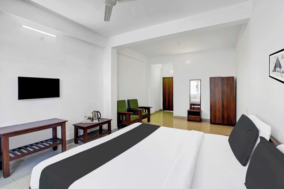 Una habitación de hotel con una cama, un escritorio, una silla, un televisor y un armario.