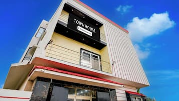 Un edificio de varios pisos con un letrero llamativo que dice 'TOWNHOUSE' y 'Company-Serviced'.