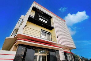 Un edificio de varios pisos con un letrero llamativo que dice 'TOWNHOUSE' y 'Company-Serviced'.