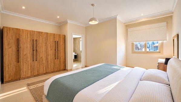 A bedroom with a bed, a wardrobe, and a window.