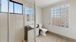 Ein Badezimmer mit Dusche, Toilette und Waschbecken.