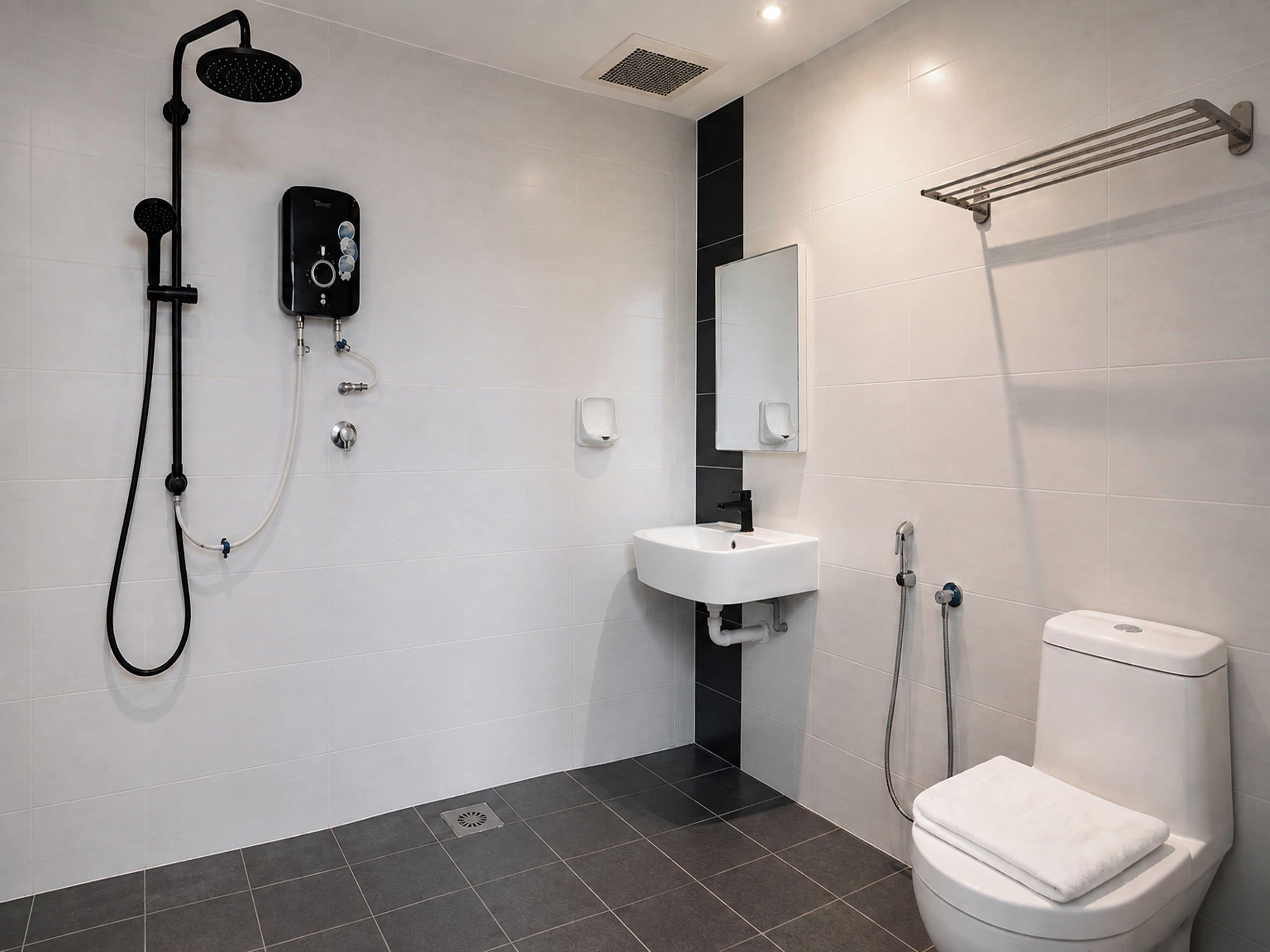 Un baño moderno con ducha, lavamanos e inodoro.
