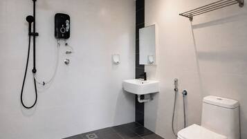 Un baño moderno con ducha, lavamanos e inodoro.