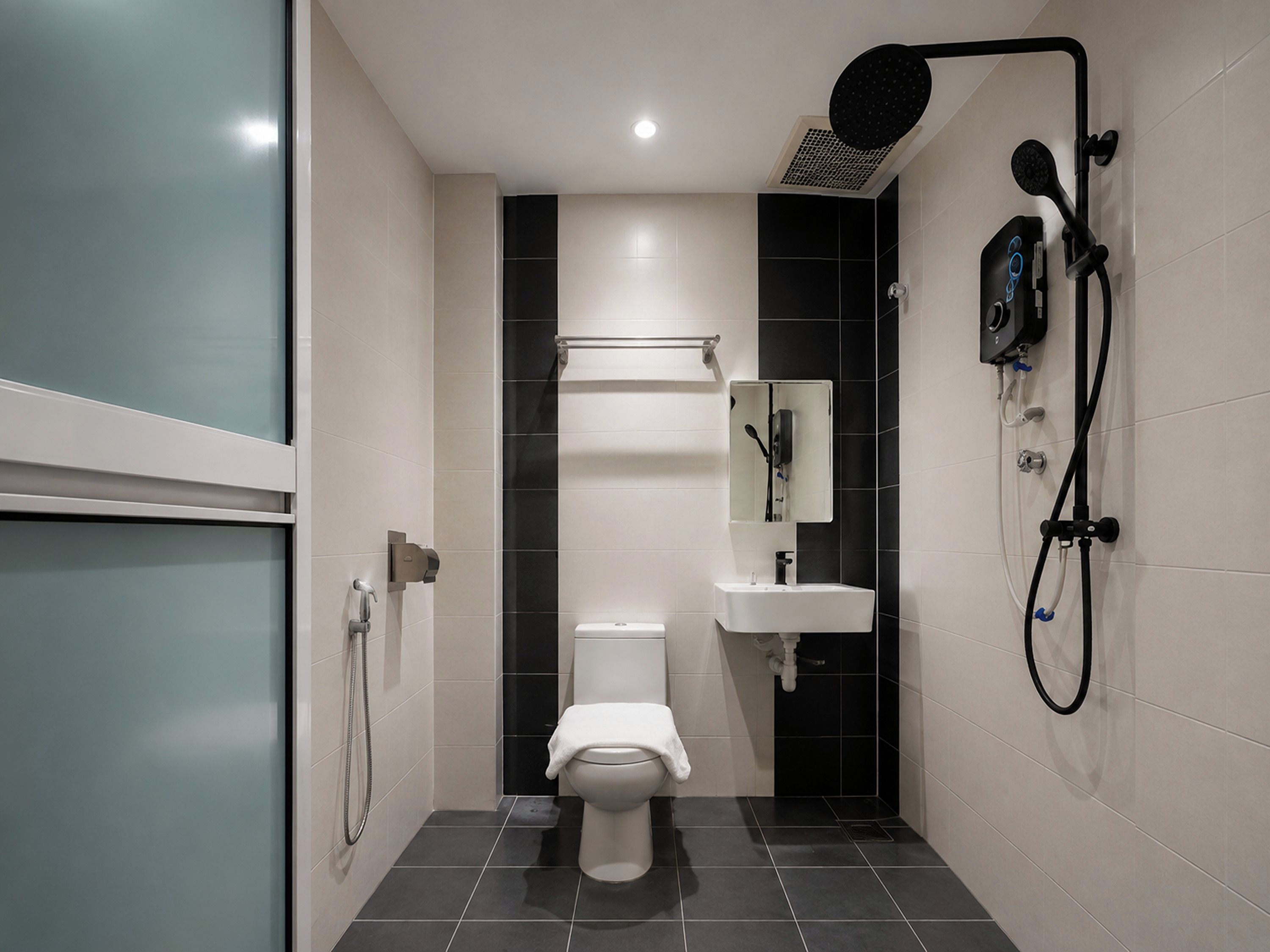 A modern bathroom with a toilet, a sink, and a shower unit.