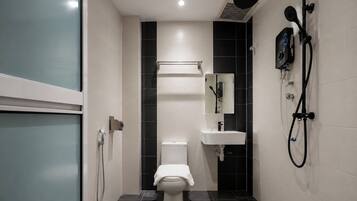 A modern bathroom with a toilet, a sink, and a shower unit.