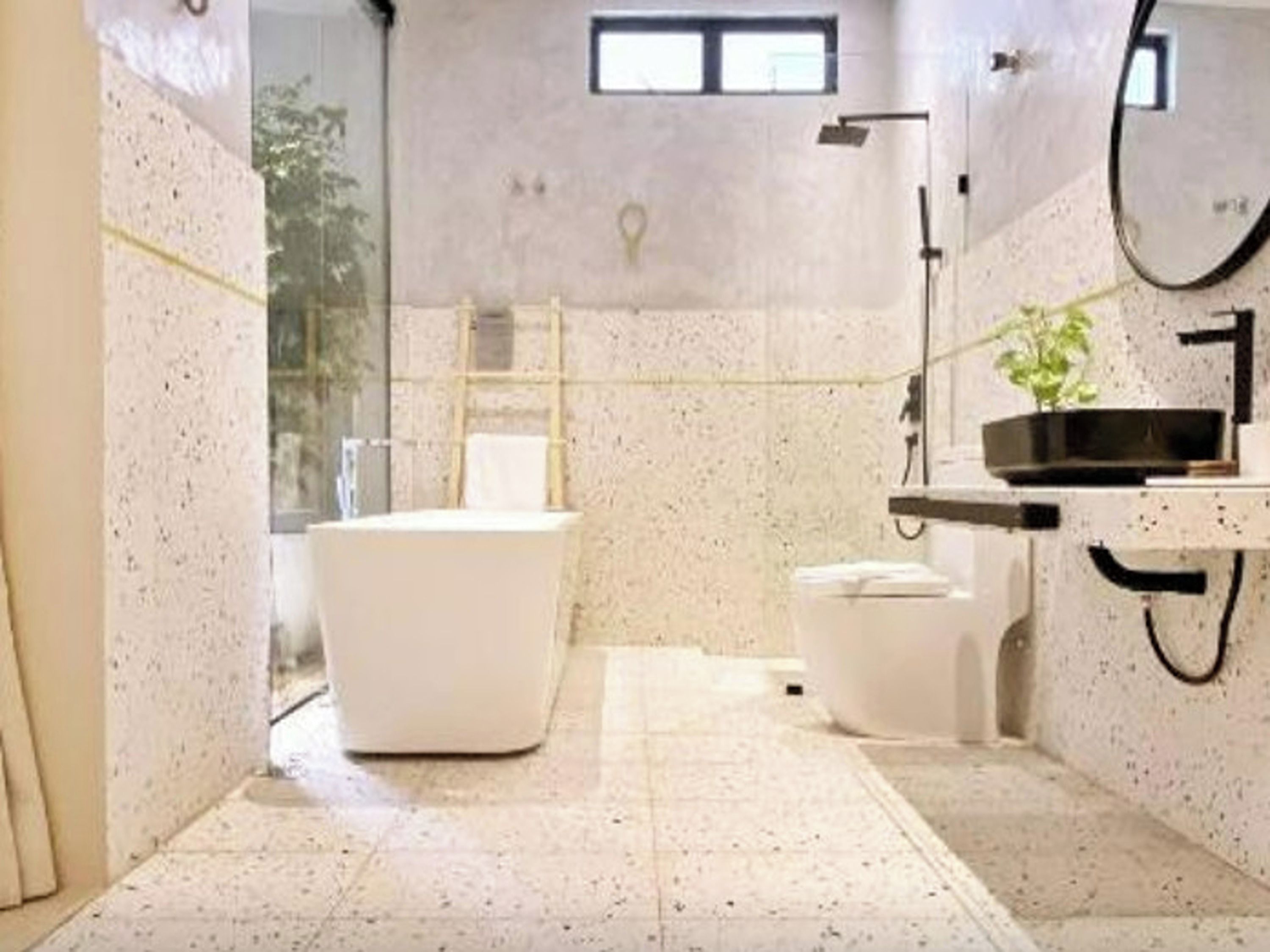 A bathroom with a freestanding bathtub, a toilet, and a sink with a mirror.