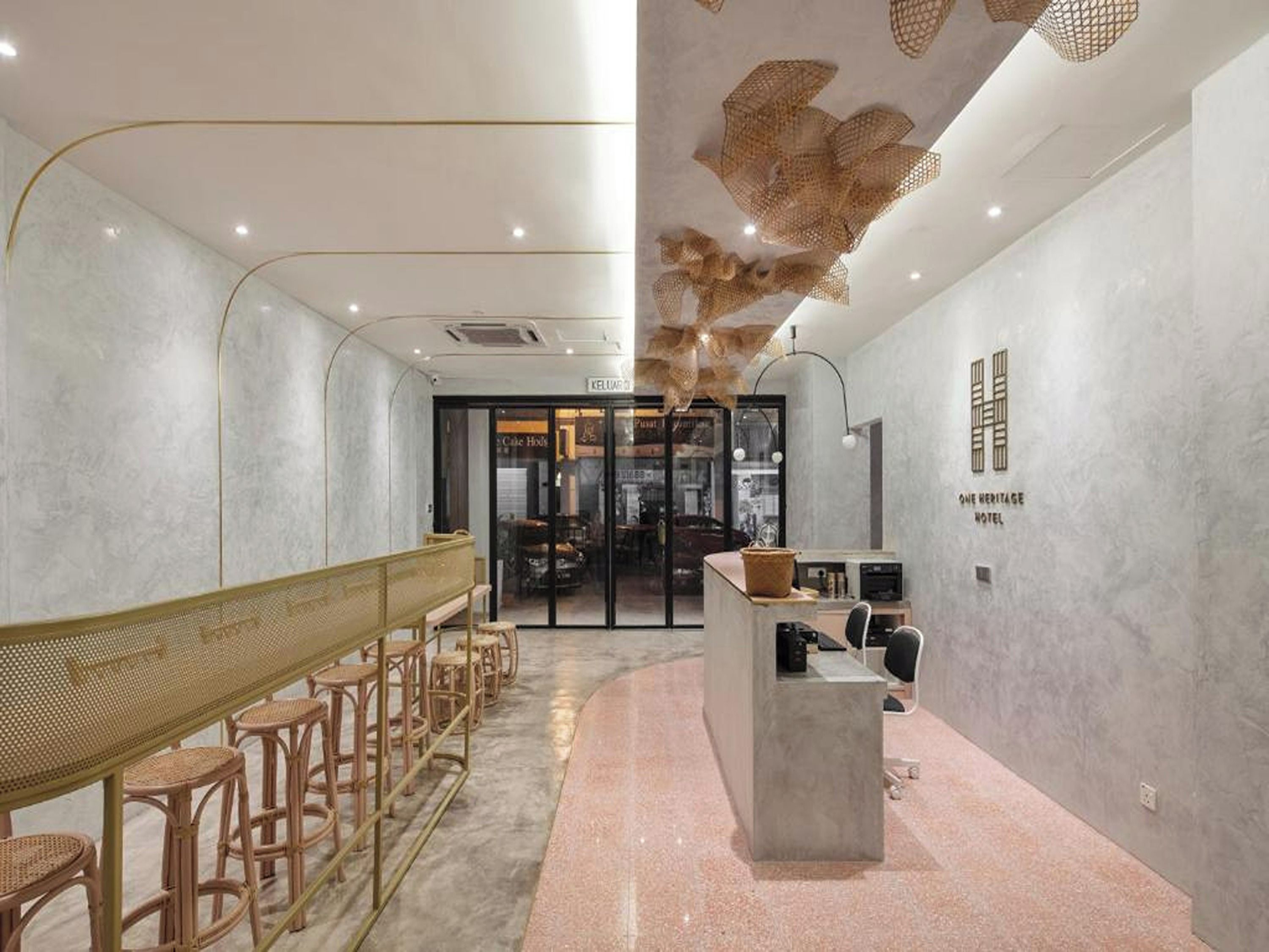 Een hotel lobby met een receptiebalie, een zithoek en uitzicht op het restaurant.