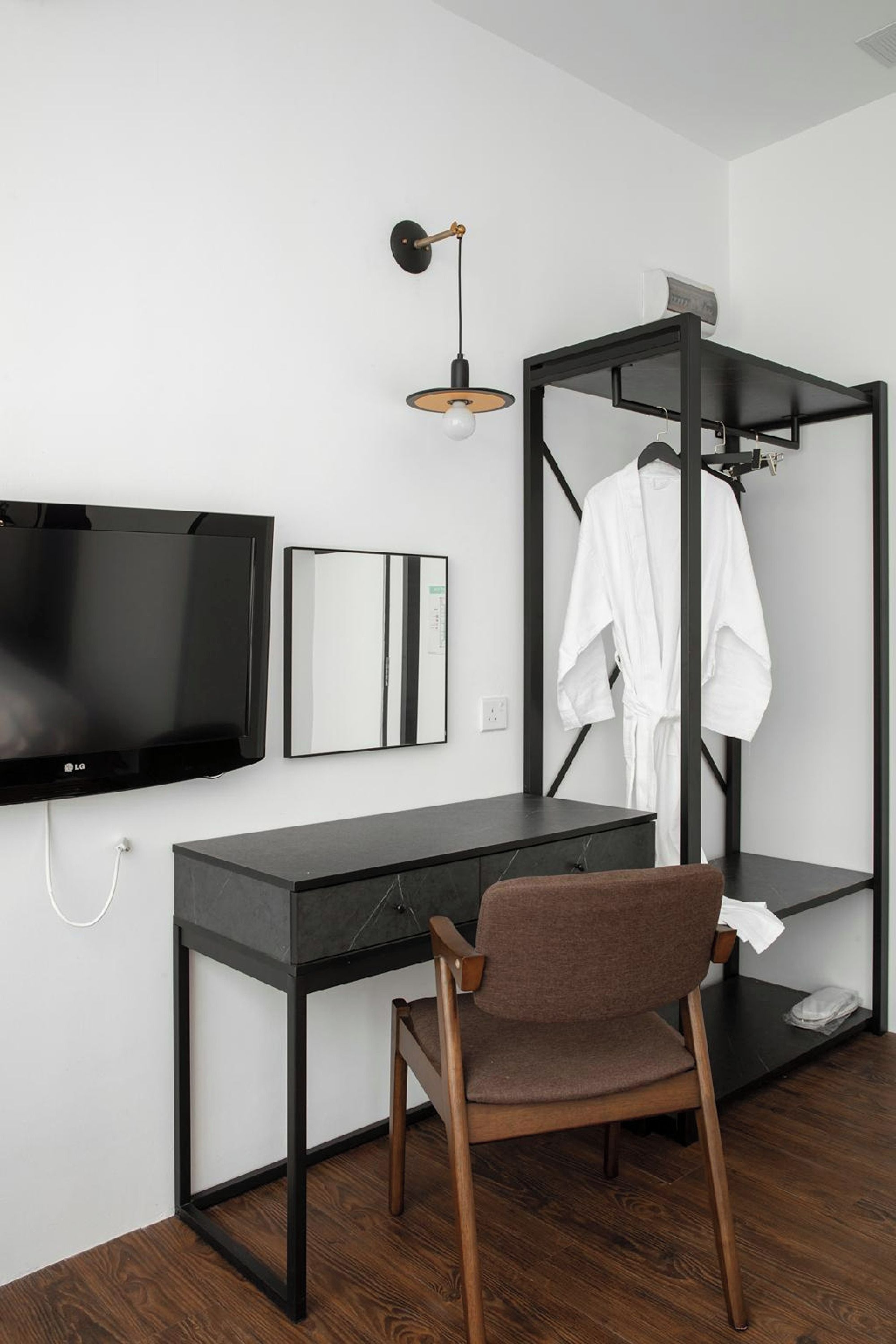 Ein modernes Schlafzimmer mit Etagenbett, Schreibtisch, Flachbildfernseher, Stuhl und einer Pendelleuchte.