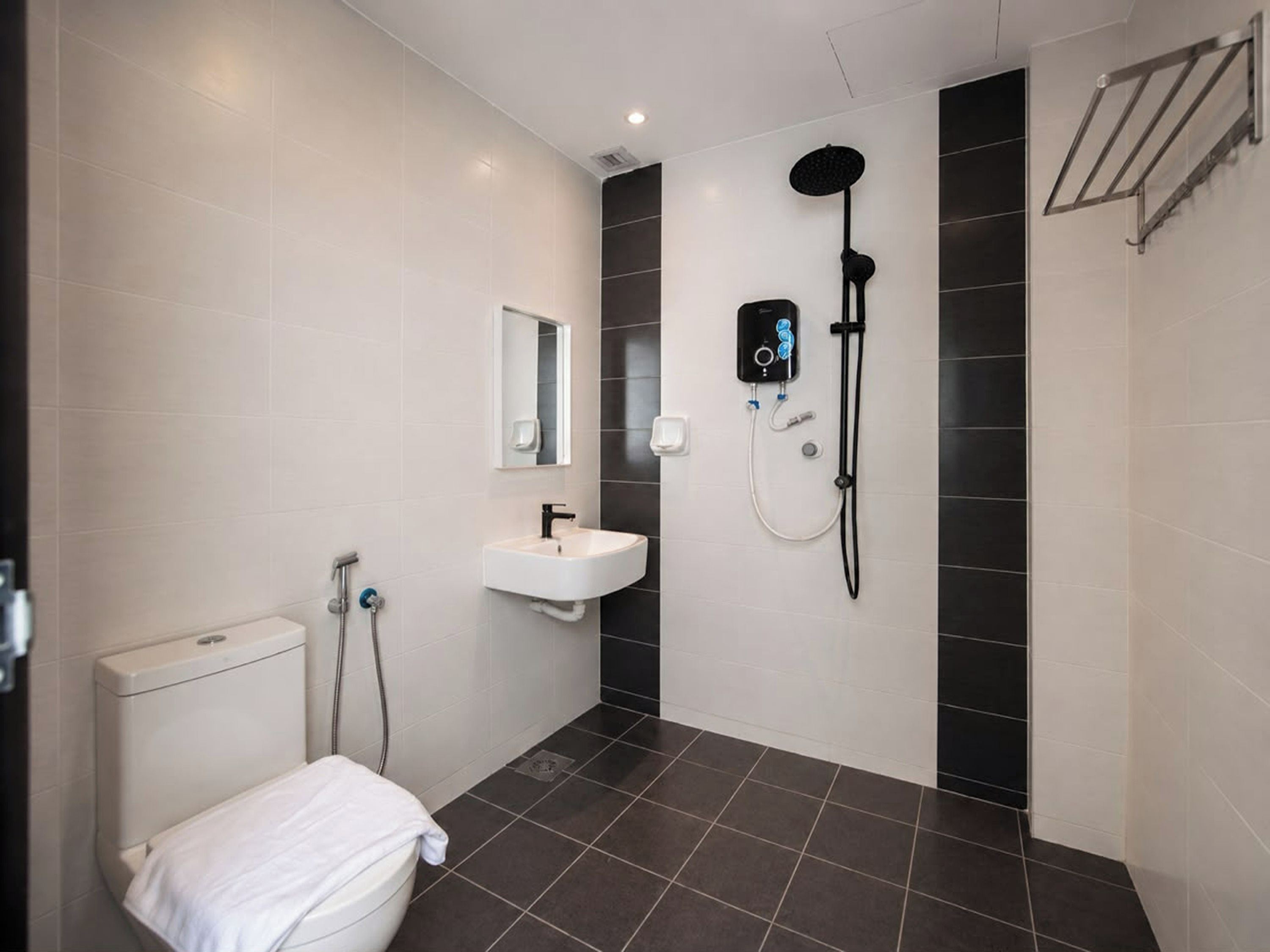A modern bathroom with a toilet, sink, and shower.