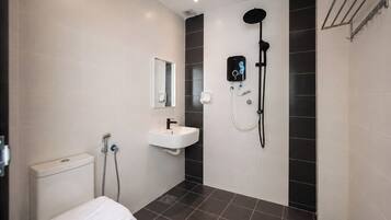 A modern bathroom with a toilet, sink, and shower.