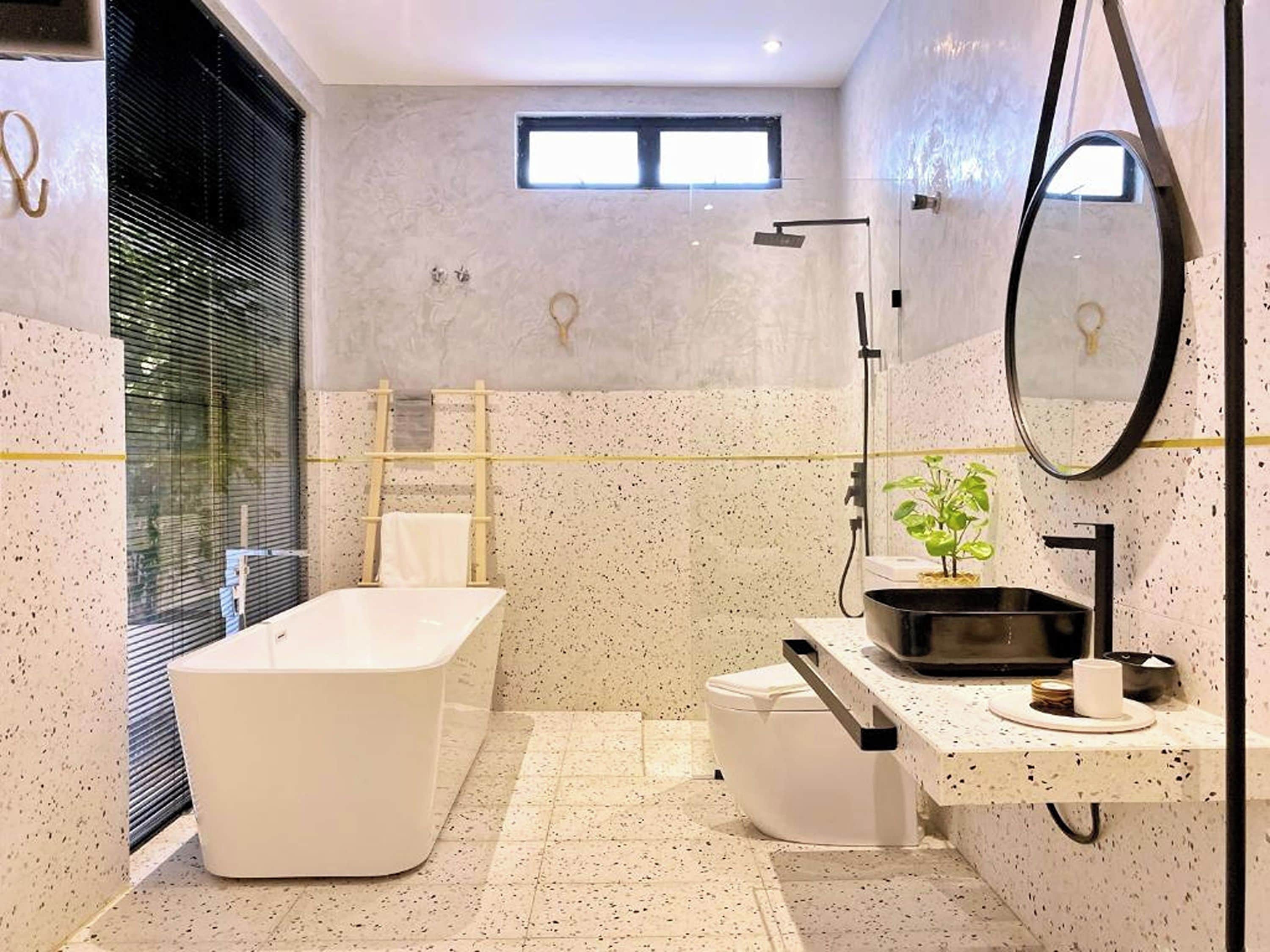 Une salle de bain moderne avec une baignoire sur pieds, des toilettes et un lavabo avec un miroir.