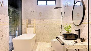Une salle de bain moderne avec une baignoire sur pieds, des toilettes et un lavabo avec un miroir.