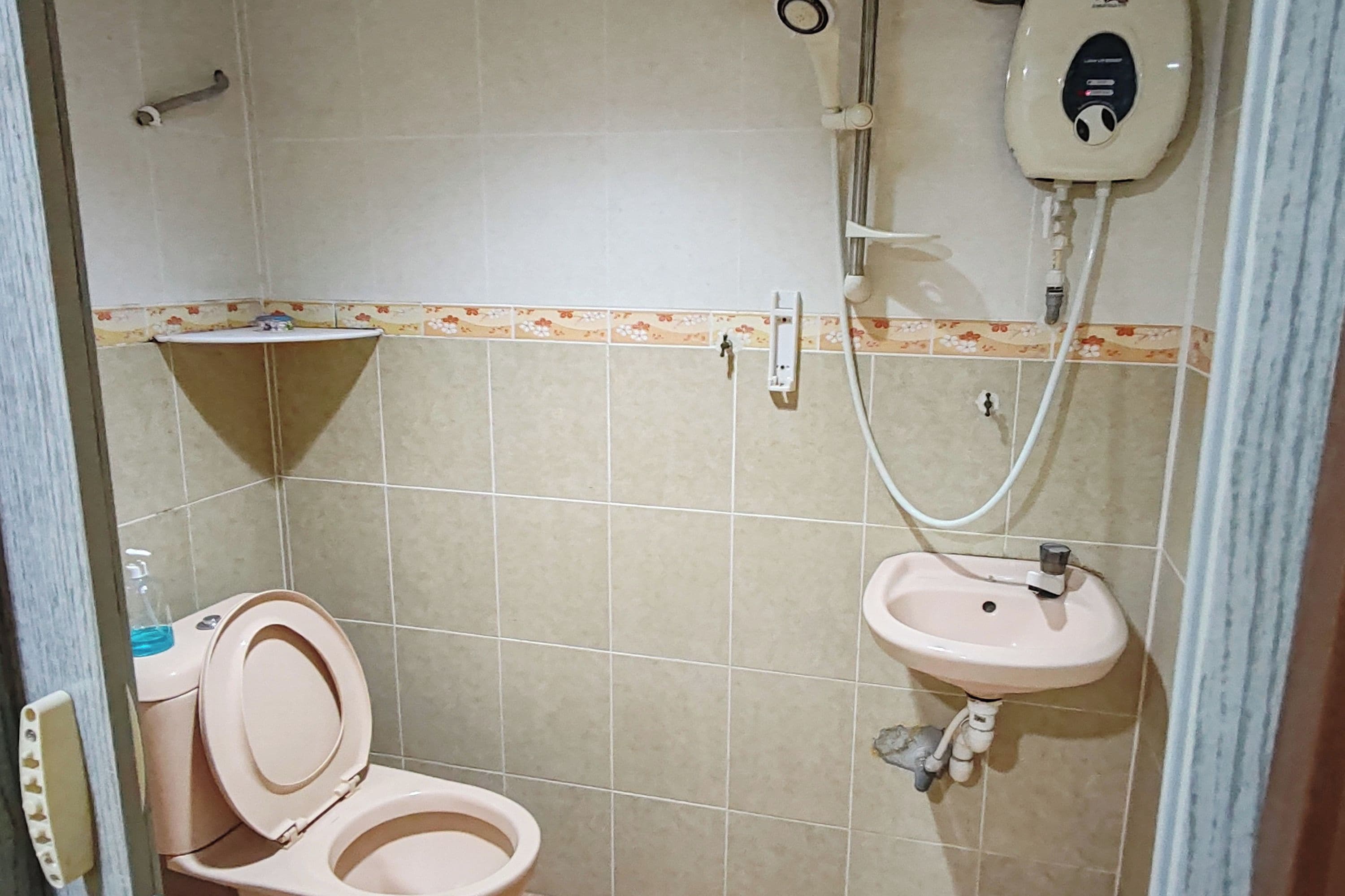 Um banheiro pequeno com vaso sanitário, pia e chuveiro.