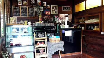 A coffee shop interior with a counter, menu boards, and a display case.