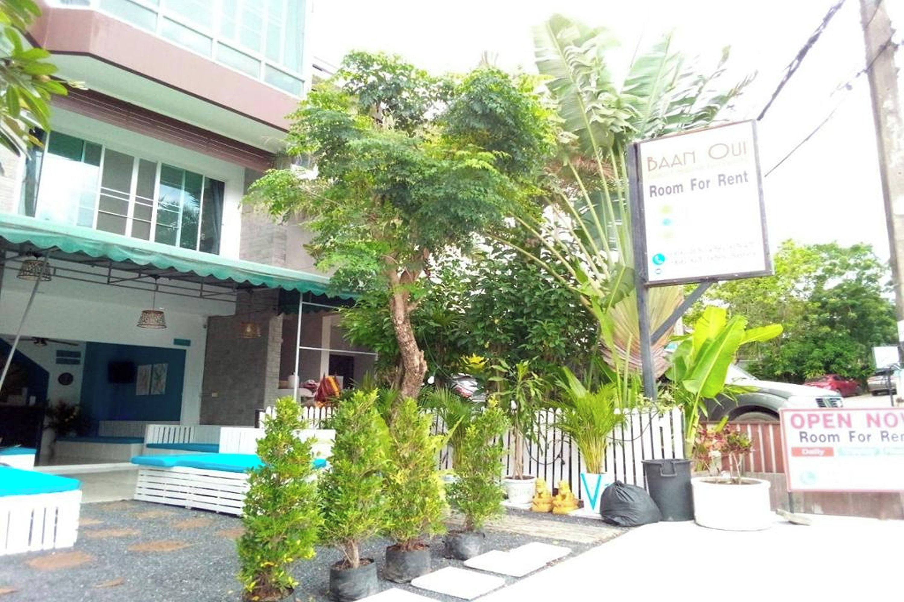 Un edificio con un cartel que indica 'Room For Rent' y un cartel que dice 'Baai Ou'.