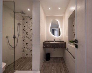 A modern bathroom with a glass shower enclosure, a marble sink, and a large mirror. - Lovely Home at 22 by Spacey #46 (cairo)