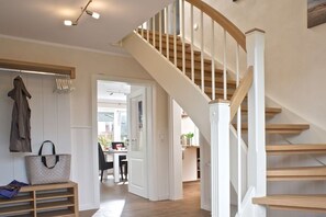 A staircase with wooden steps and white railings leading to an upper floor. - Holiday home in Tating with swimming pool (Tating)
