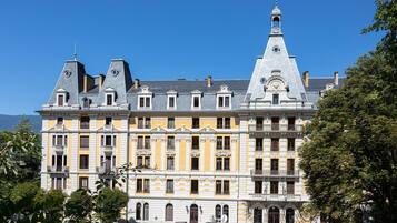 A multi-story building with a classic architectural style, featuring a prominent tower and a series of balconies.