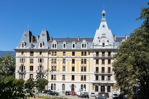 Ein mehrstöckiges Gebäude im klassischen Stil, mit einem markanten Turm und einer Reihe von Balkonen.