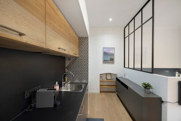 Una cucina moderna con mobili in legno, un piano di lavoro nero e un rivestimento a parete decorato.