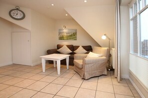 A living room with a sofa, armchair, and a small table. - Rungholtstraße 6a, Holiday Apartment 3 (Wyk auf Föhr)