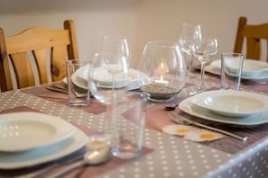 A dining table set with plates, glasses, and a candle. - 5 in the house Sturmmöwe (ID 117) (St. Peter-Ording)