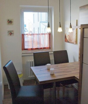 Ein Essbereich mit Tisch, Stühlen und Pendelleuchten.