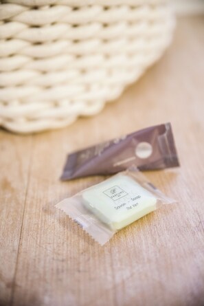 A wooden surface with a woven basket and two small packets, one labeled 'PARFUMS de' and the other 'Savon - Soap'.