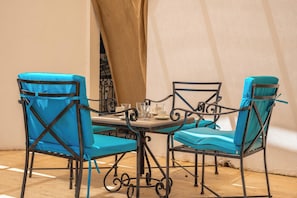 A dining area with a table and four chairs, each with a blue cushion. - Villa with stunning sea view and private pool (Kaş)
