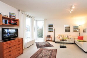 A living room with a television, a sofa, a coffee table, and a bookshelf. - 11 in the house at Blanker-Hans-Weg 5 (ID 081) (St. Peter-Bad)