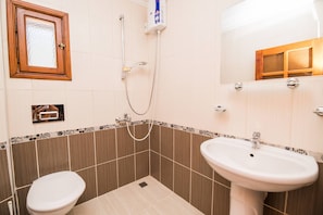 Un bany amb vàter, rentapel, dutxa i mirall.
