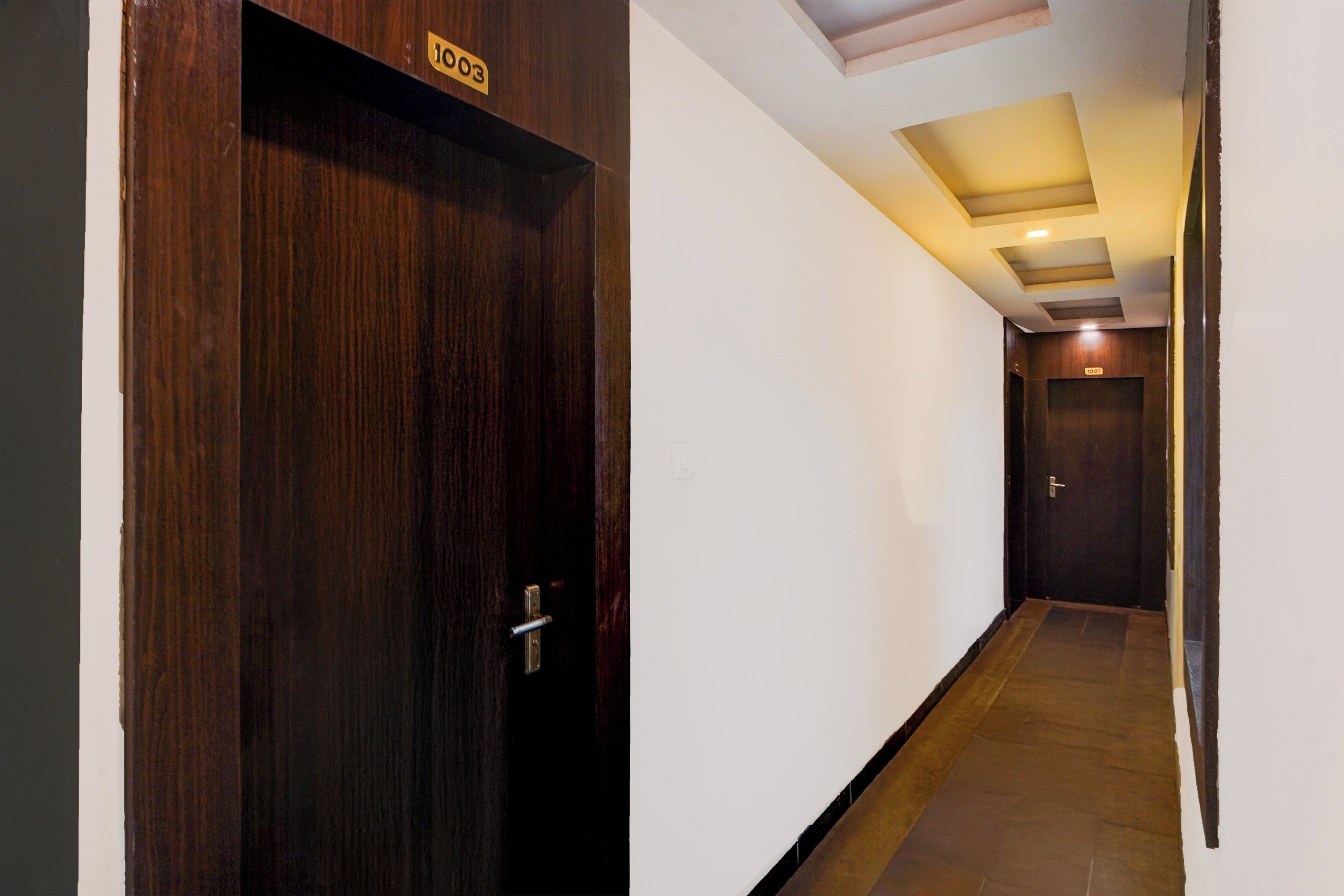 A hallway with a wooden door labeled '1003' and a door labeled '1001' at the end.