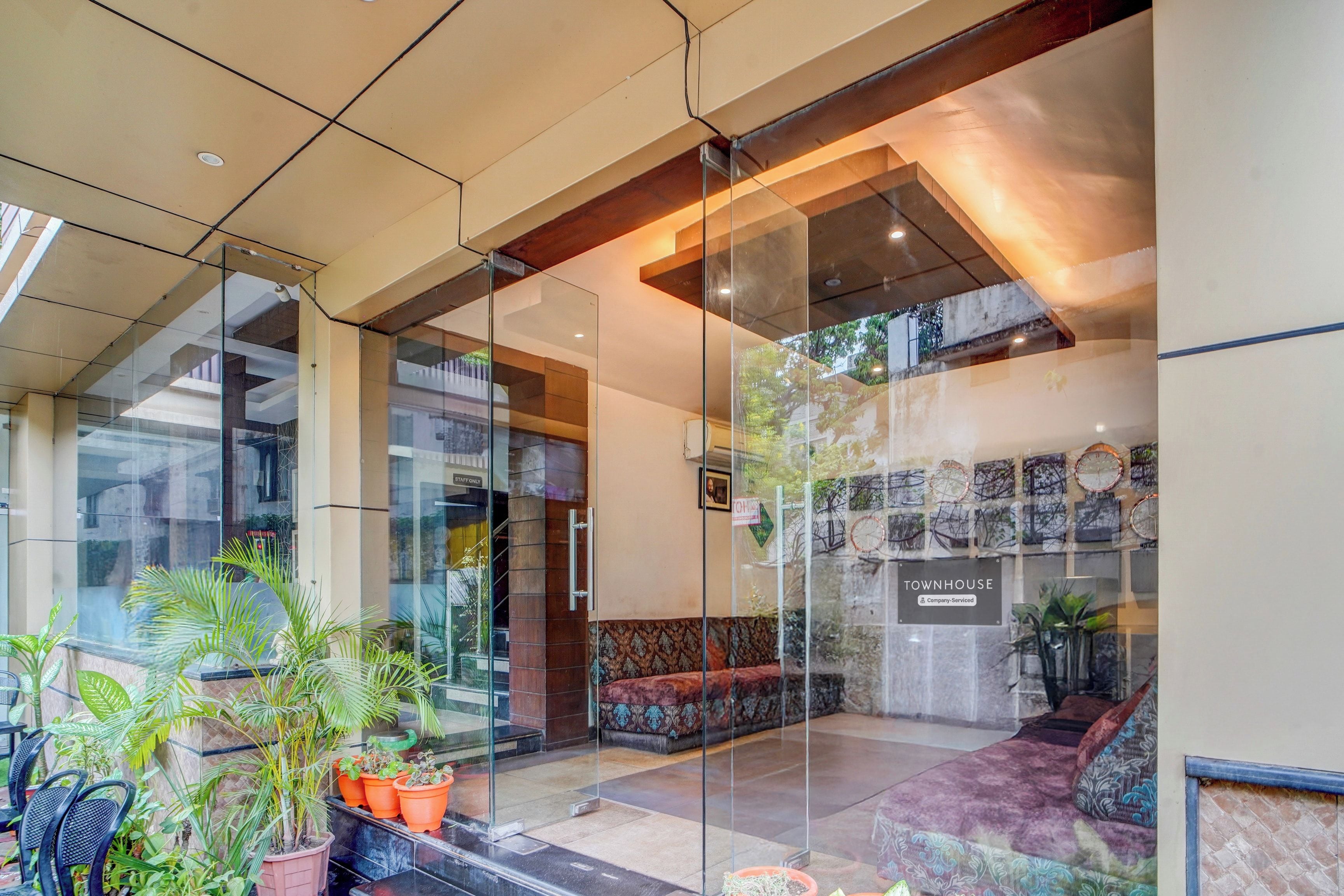 A modern interior with glass partitions, a seating area, and a wall displaying various items.