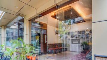 A modern interior with glass partitions, a seating area, and a wall displaying various items.