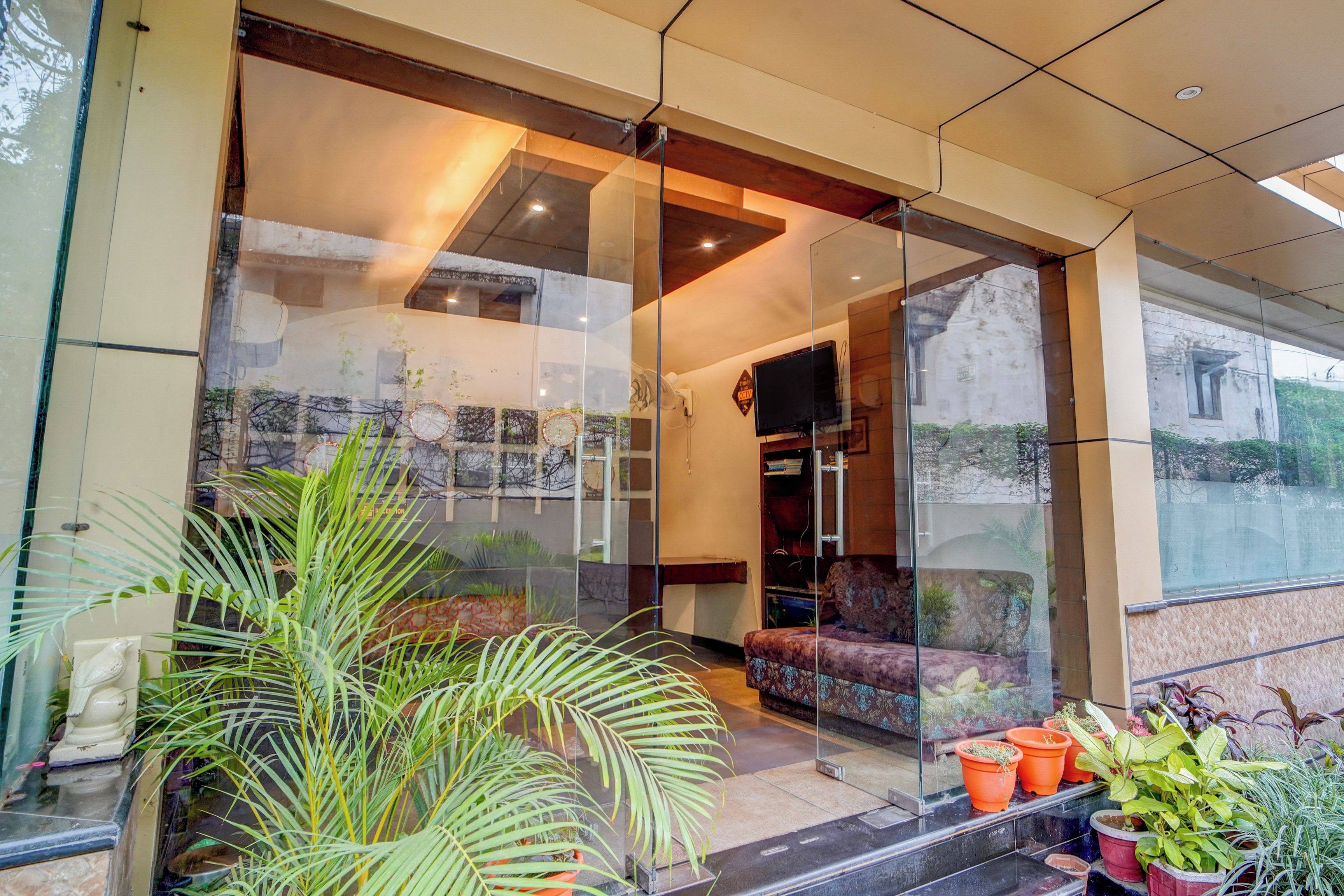 A modern interior with a glass partition, a sofa, and potted plants.