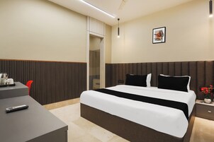 Una habitación de hotel con una cama, una mesita de noche y un escritorio con silla.