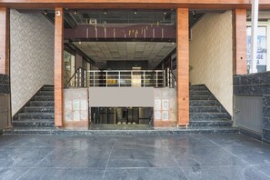 Una entrada de edificio con una escalera que lleva a un rellano en el segundo piso.