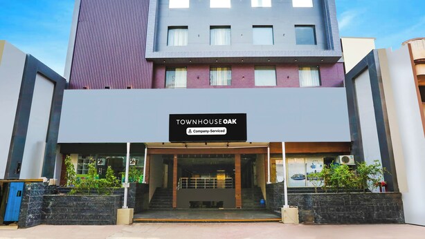 A modern building with a sign reading 'TOWNHOUSE OAK Company Serviced'.